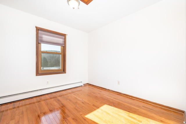 spare room featuring hardwood / wood-style floors and baseboard heating