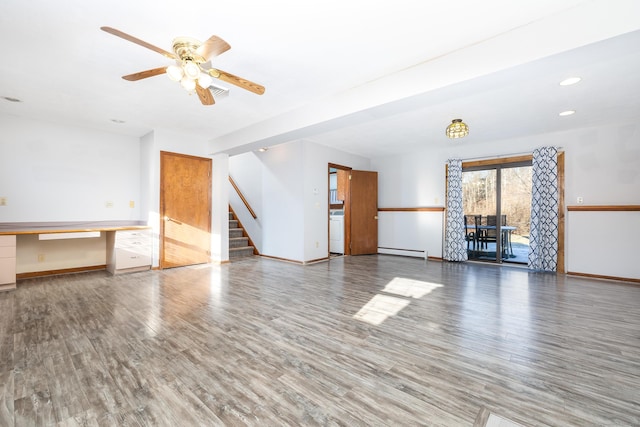 unfurnished living room with ceiling fan, built in desk, wood-type flooring, and a baseboard radiator