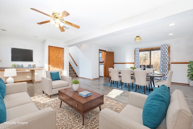 living room featuring ceiling fan and light hardwood / wood-style floors