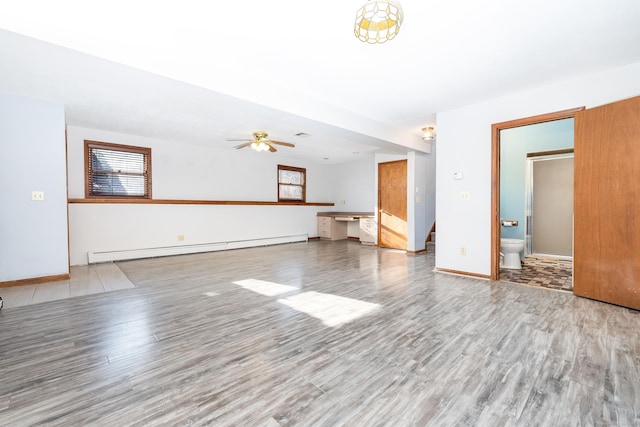 unfurnished living room featuring hardwood / wood-style flooring, ceiling fan, and a baseboard heating unit