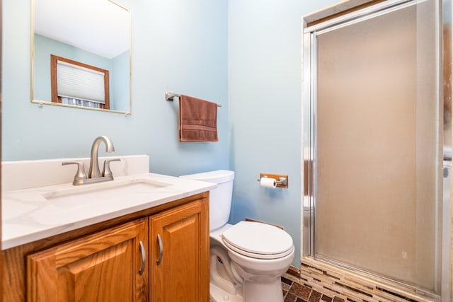 bathroom featuring vanity, toilet, and walk in shower