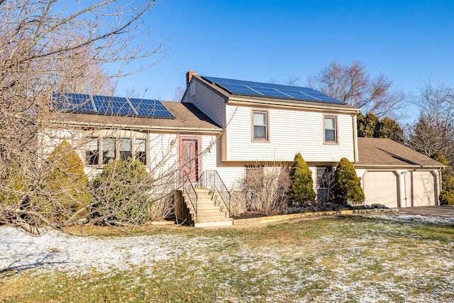 view of front of property with solar panels and a garage