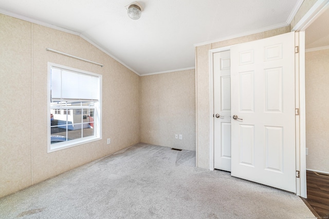 unfurnished bedroom with ornamental molding, lofted ceiling, and wood-type flooring