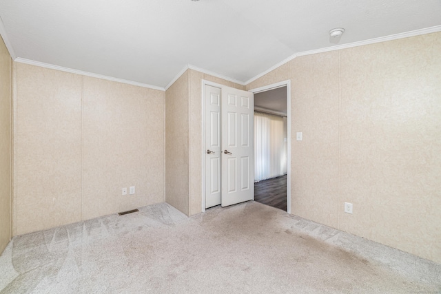 carpeted empty room featuring lofted ceiling and ornamental molding