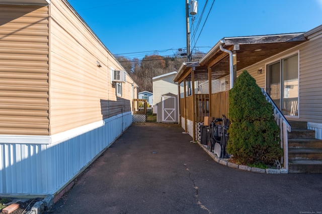 view of side of home with a storage shed