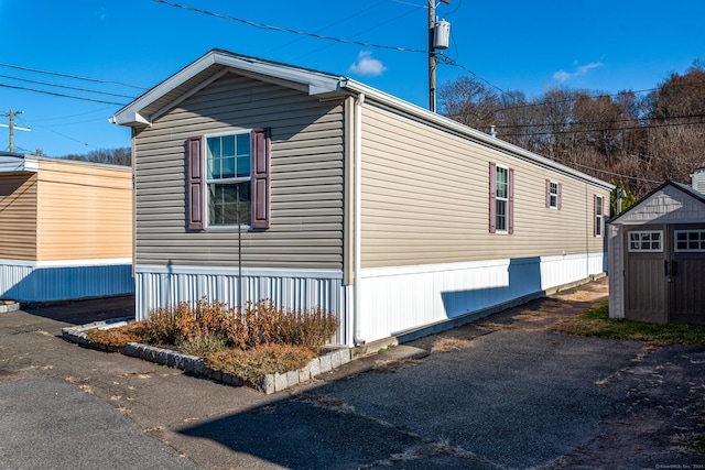 view of side of home featuring a storage shed