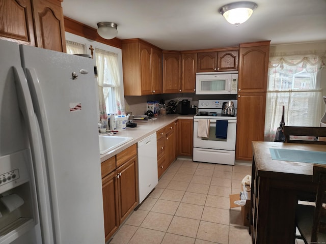 kitchen with sink, light tile patterned floors, and white appliances