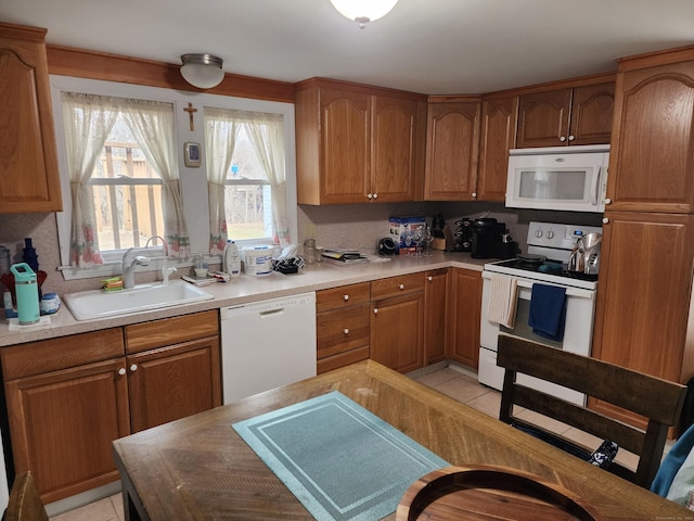 kitchen featuring white appliances, sink, and light tile patterned floors