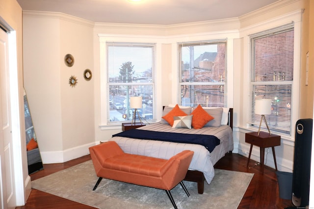 bedroom with crown molding and dark hardwood / wood-style floors