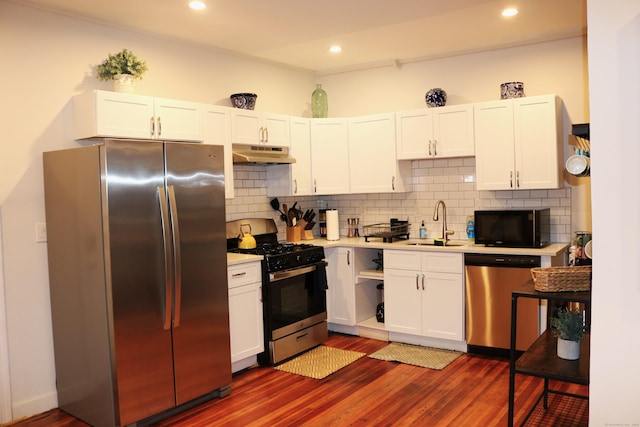 kitchen featuring backsplash, dark hardwood / wood-style flooring, stainless steel appliances, sink, and white cabinetry