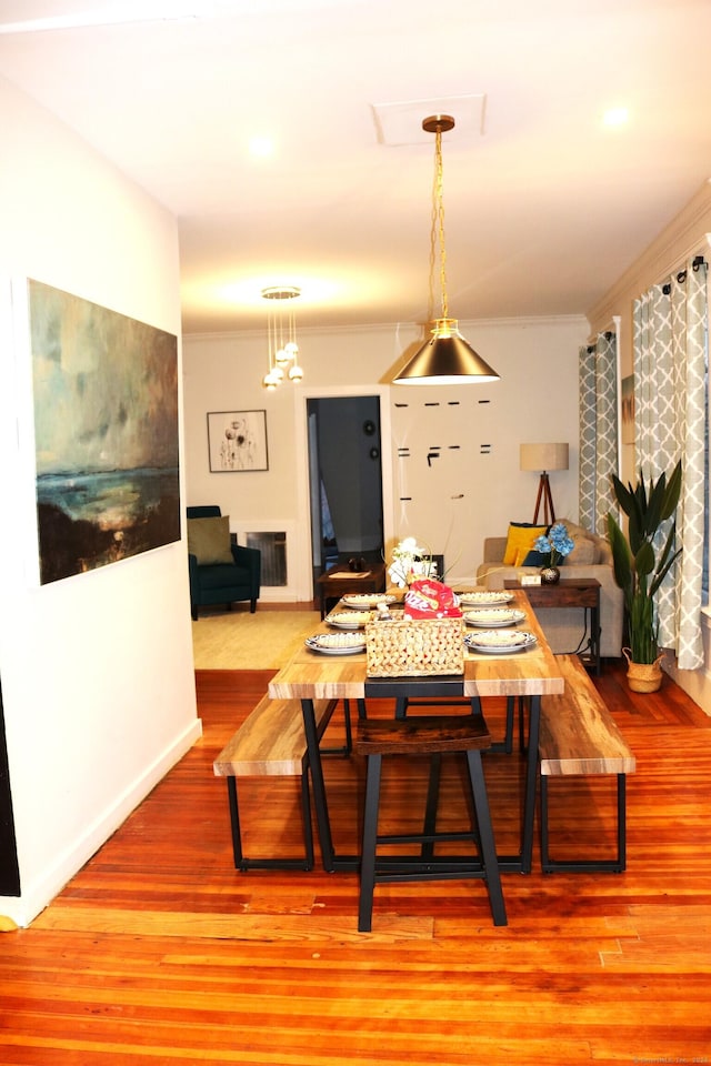 dining room with light hardwood / wood-style floors and crown molding