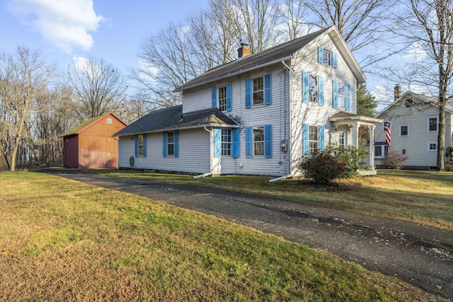 view of front of house featuring a front lawn and an outdoor structure