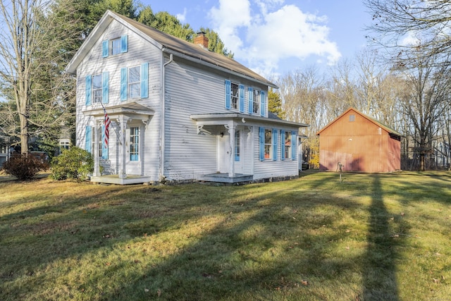 view of front of home featuring an outbuilding and a front lawn