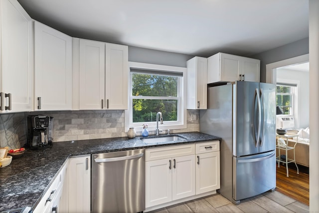 kitchen with sink, white cabinets, light wood-type flooring, and appliances with stainless steel finishes