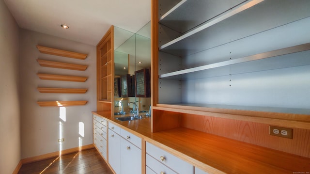 kitchen with sink, white cabinets, and dark hardwood / wood-style floors