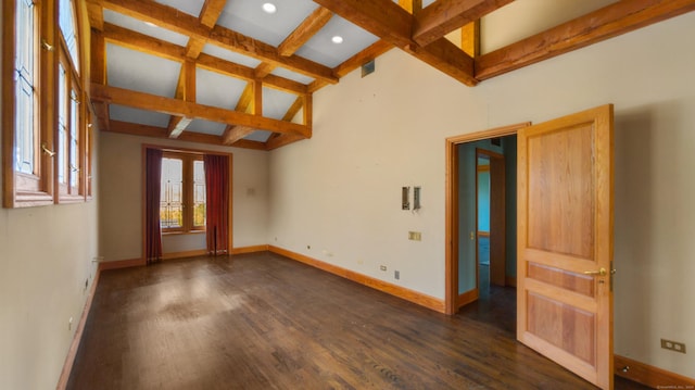 spare room featuring dark wood-type flooring and beam ceiling