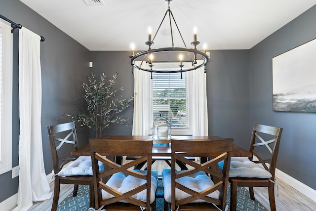 dining space featuring hardwood / wood-style flooring and a notable chandelier