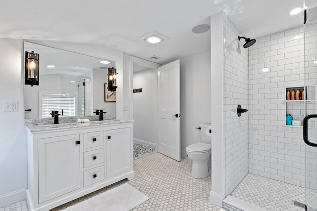 bathroom featuring vanity, a shower with shower door, and toilet