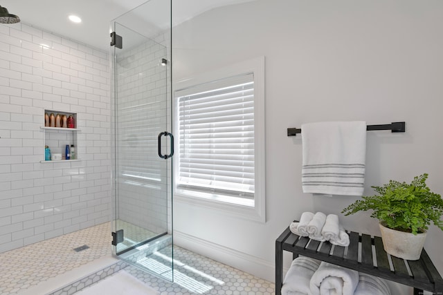 bathroom with tile patterned floors, vaulted ceiling, and a shower with door