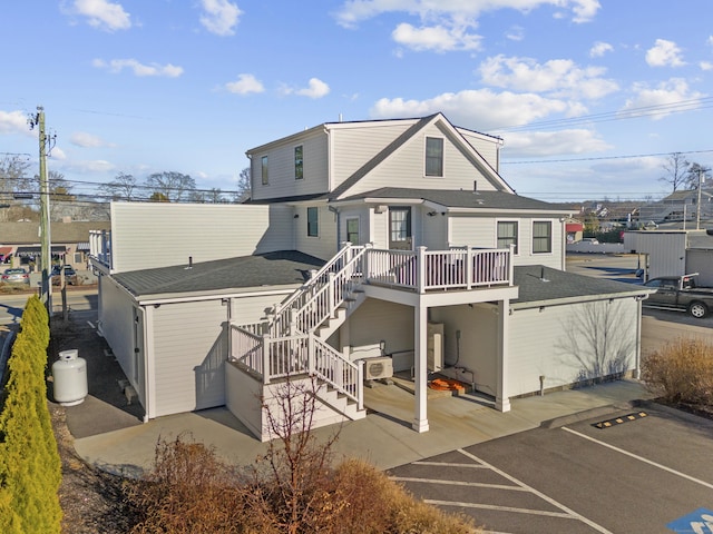 rear view of house featuring a wooden deck and a patio