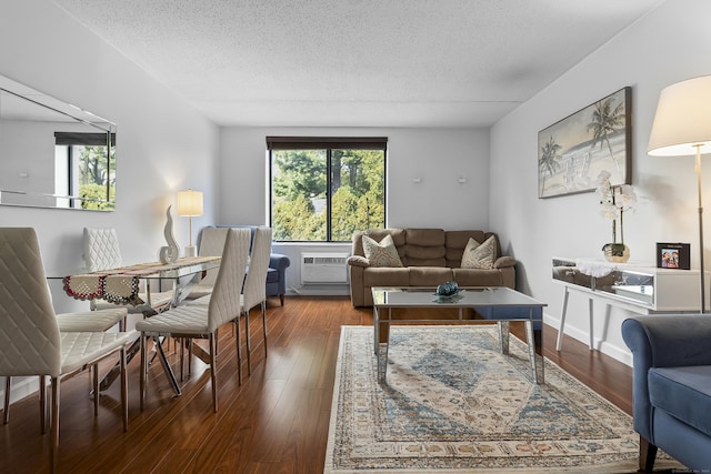 living room with a wall mounted AC, dark hardwood / wood-style flooring, and a textured ceiling