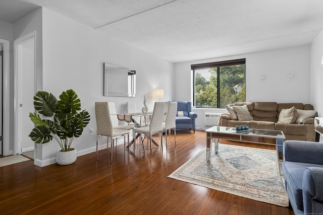 living room featuring a wall mounted air conditioner, a textured ceiling, and hardwood / wood-style flooring