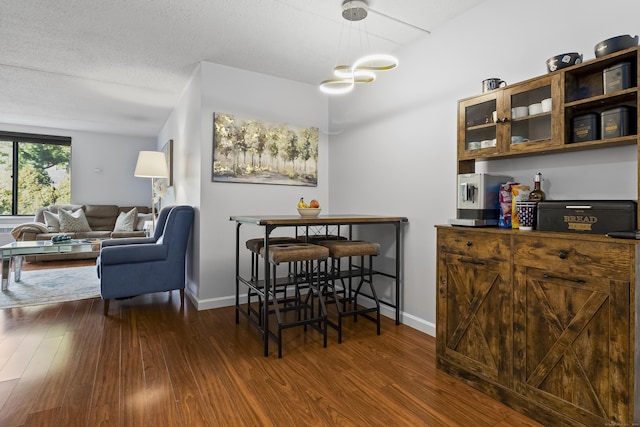 dining area with dark wood-type flooring and a textured ceiling