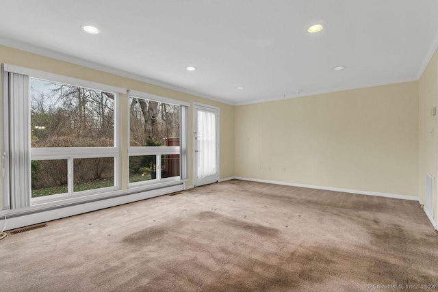 carpeted spare room with a baseboard radiator and crown molding