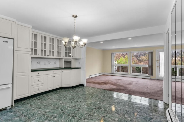 kitchen featuring dark colored carpet, white fridge, white cabinetry, and baseboard heating