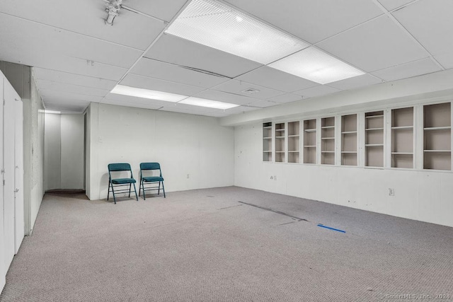 basement with carpet flooring and a paneled ceiling