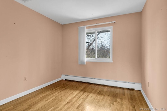 unfurnished room with light hardwood / wood-style flooring and a baseboard heating unit