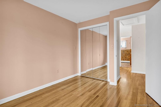 unfurnished bedroom featuring a closet and hardwood / wood-style flooring