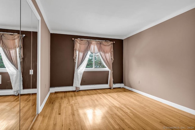 unfurnished room featuring light wood-type flooring and ornamental molding