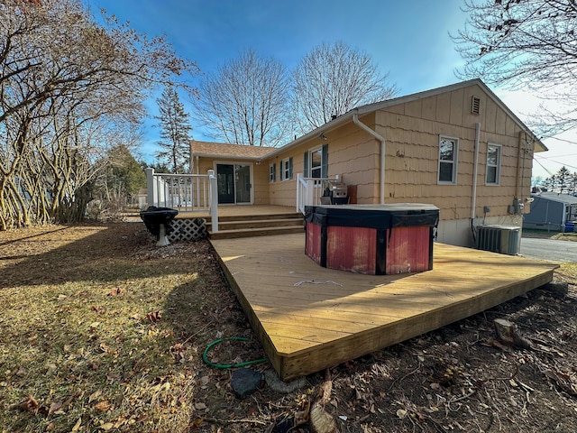 rear view of property featuring central AC, a hot tub, and a deck