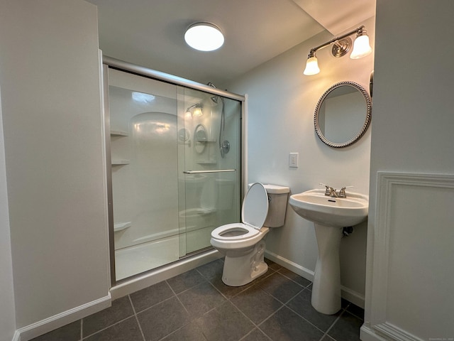 bathroom featuring tile patterned floors, toilet, an enclosed shower, and sink