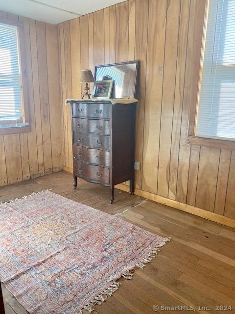 bedroom featuring light wood-type flooring and wooden walls