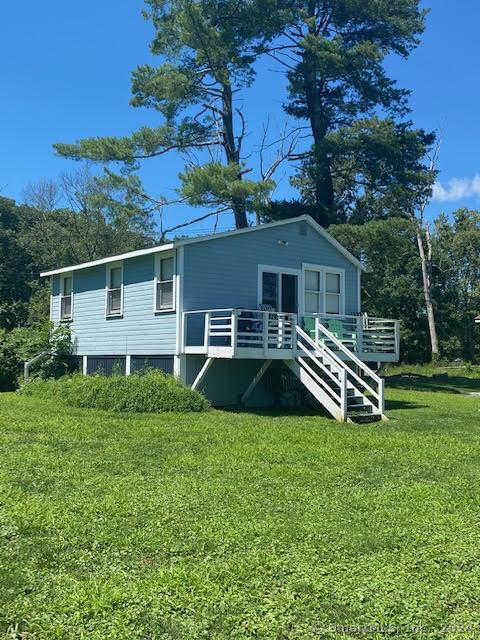 back of house featuring a lawn and a deck