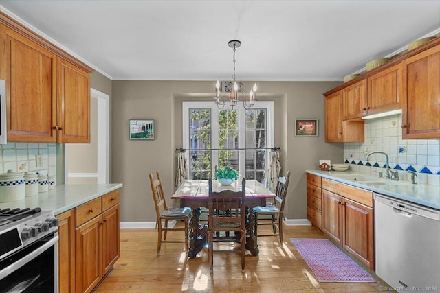 kitchen with decorative backsplash, light hardwood / wood-style flooring, stainless steel appliances, and a notable chandelier