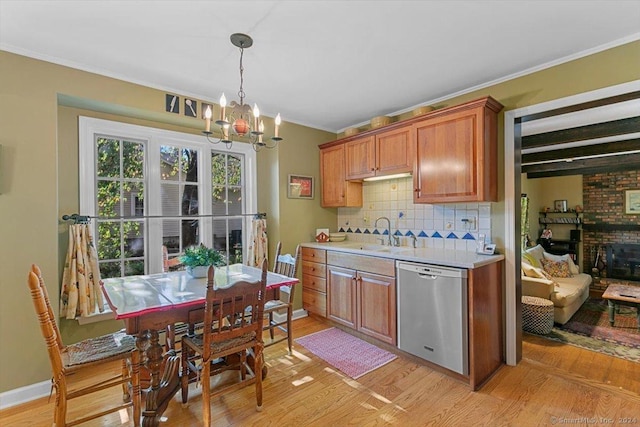 kitchen featuring sink, light hardwood / wood-style flooring, stainless steel dishwasher, backsplash, and crown molding