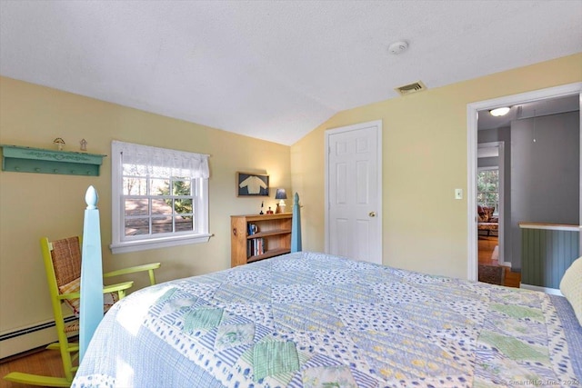 bedroom featuring hardwood / wood-style flooring, baseboard heating, and vaulted ceiling