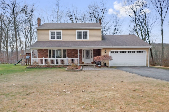 view of front of property featuring a porch, a garage, and a front lawn