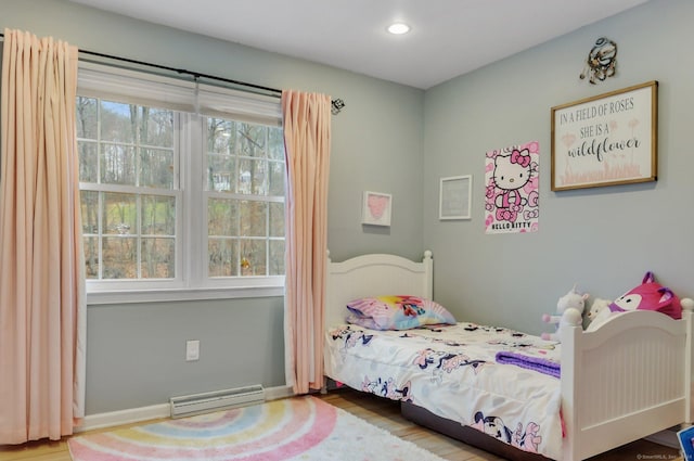 bedroom featuring hardwood / wood-style floors and a baseboard radiator