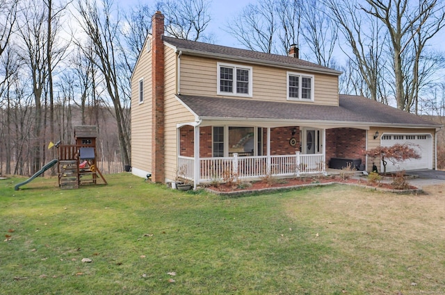 view of front facade with a front yard, a porch, a playground, and a garage