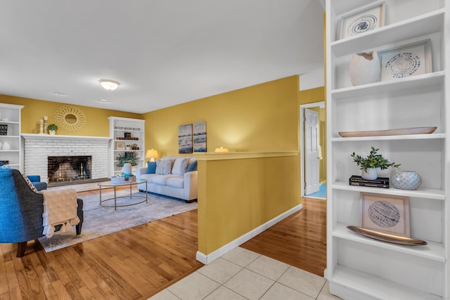 living room featuring light tile patterned floors and a brick fireplace