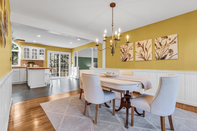 dining area featuring beamed ceiling, dark tile patterned floors, and a notable chandelier