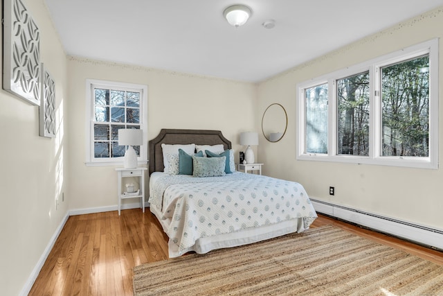 bedroom featuring hardwood / wood-style floors and baseboard heating