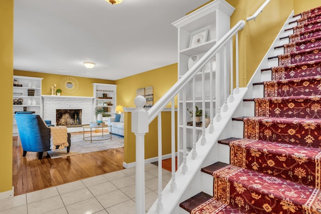 staircase with tile patterned flooring and a fireplace