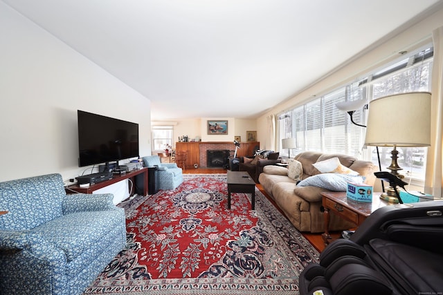 living room with hardwood / wood-style flooring and a brick fireplace