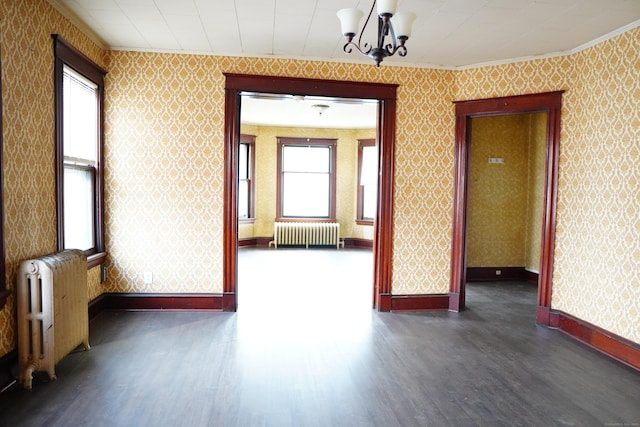 spare room featuring radiator heating unit, crown molding, and a chandelier