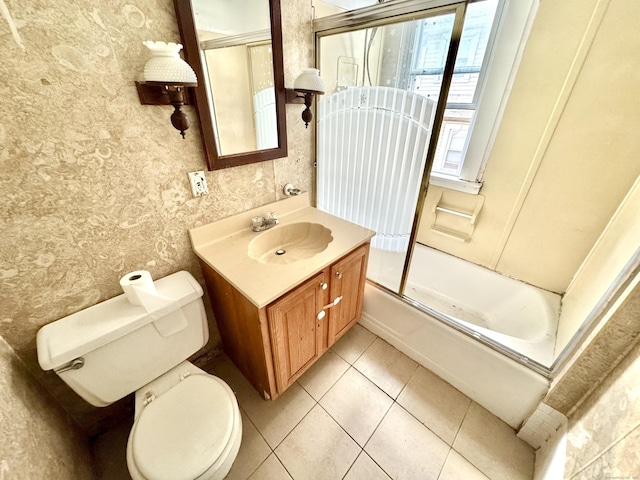 full bathroom featuring tile patterned flooring, toilet, combined bath / shower with glass door, and vanity